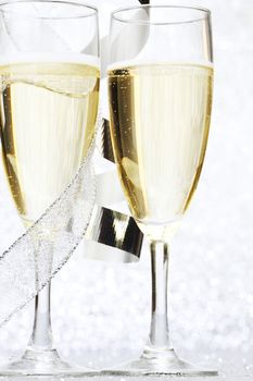 Two glasses of champagne with bow on silver background