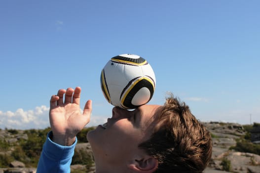 Boy balancing the ball on his face