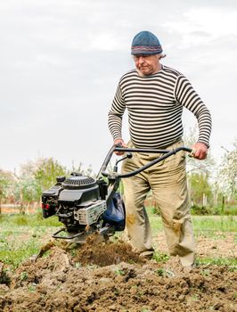 Farmer plowing the field. Cultivating tractor in the field