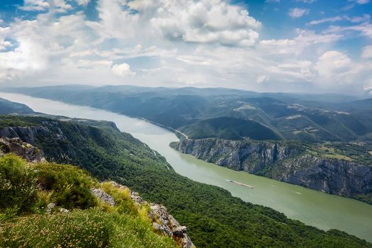 The Iron Gate Gorge is a spectacular deep gorge with high cliff walls on the River Danube dividing the Carpathian and Balkan mountains and forming part of the boundary between Serbia and Romania.
A River Landscape with a Stormy Sky