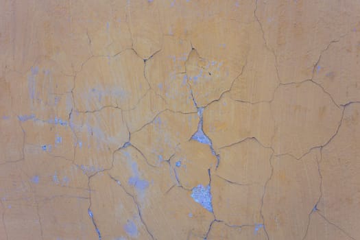 Yellow wall with cracks and peeling paint in grunge, seamless texture