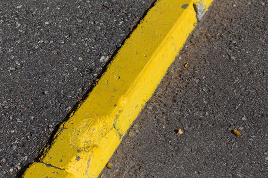 Yellow curb stone border and asphalt road