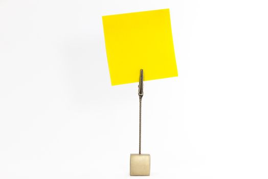 Paperclip holds empty yellow sticky note