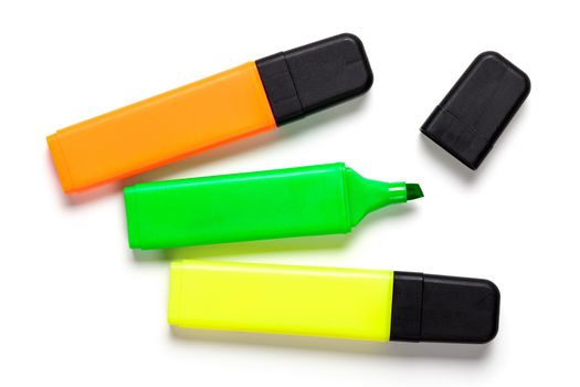 Highlighters on white background. Yellow, orange and green. Top view 