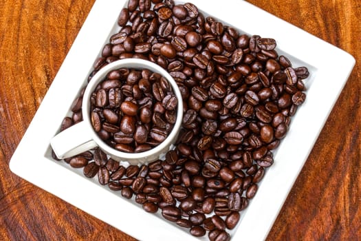 Coffee beans on the wooden background.