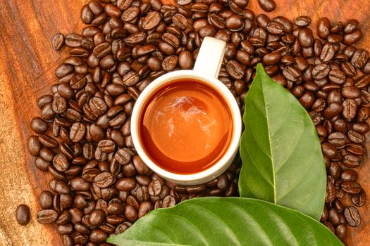 Coffee and beans on the wooden background.