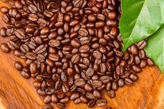 Coffee beans on the wooden background.