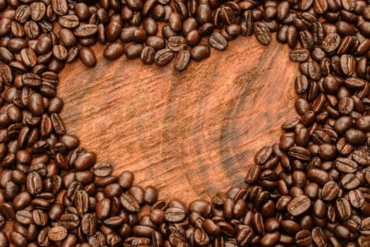 Coffee beans on the wooden background.