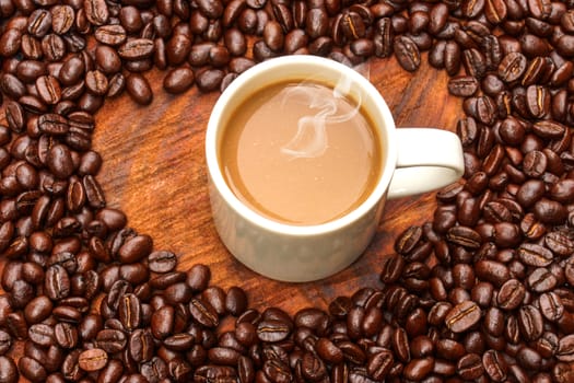 Coffee and beans on the wooden background.