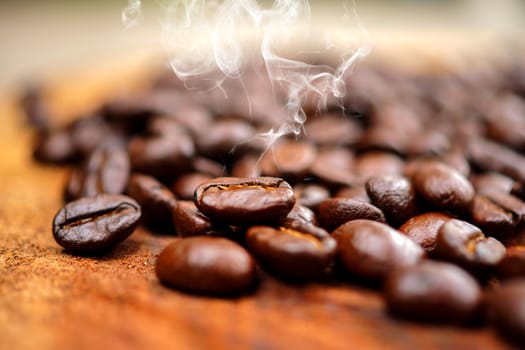 Coffee beans on the wooden background.