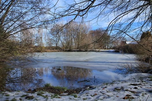 Photo presents winter countryside with snow, trees and blue sky in the Czech republic.