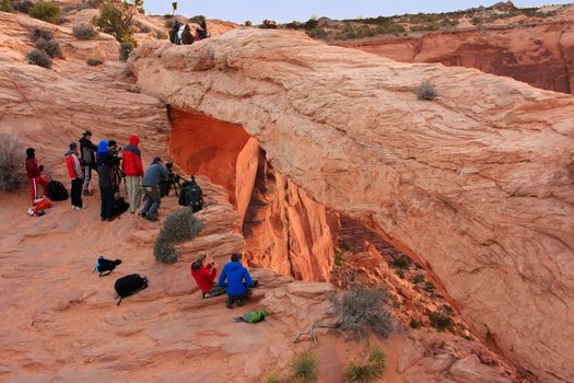 Photographers and tourists watching sunrise at  Mesa Arch, Canyonlands National Park, Utah