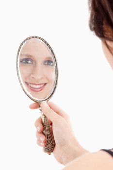 Young Woman Looking at her Reflection in Old Mirror - Isolated on White