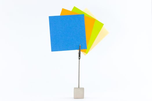 Paperclip holds sticky notes in yellow,green,orange and blue.