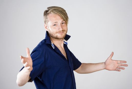 Young Man with Arms Outstretched Looking - Isolated on Gray