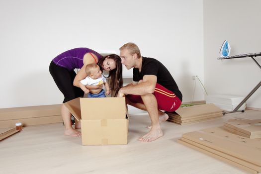 Young Family with a Baby Moving in a New Apartment