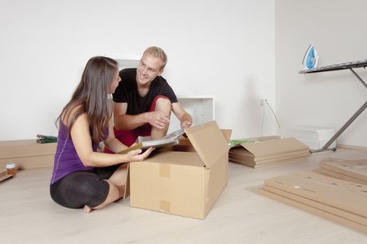 Young Couple Moving, Unpacking, Looking at Old Pictures