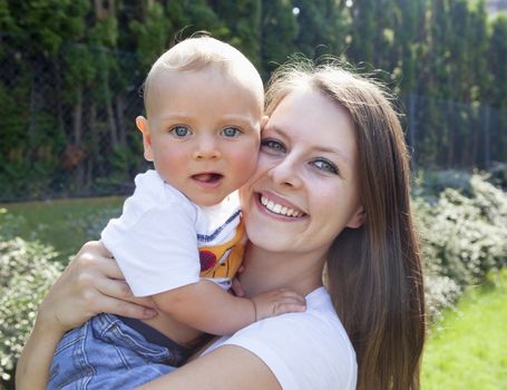 Young Mother with her Baby in the Garden Smiling