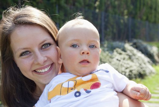 Young Mother with her Baby in the Garden Smiling