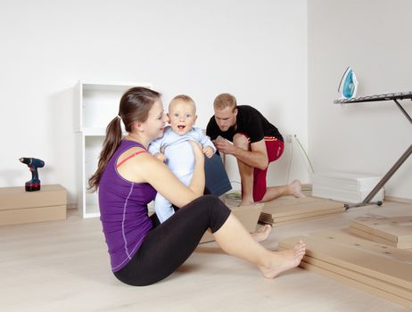 Young Family with a Baby Moving in a New Apartment