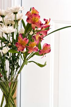 Close up of a flower arrangement with lillies in a clear vase.