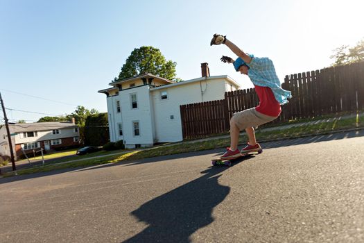 Action shot of a longboarder skating on an urban road. 