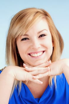 Portrait of Young Woman with Blond Hair Smiling - Isolated on Blue