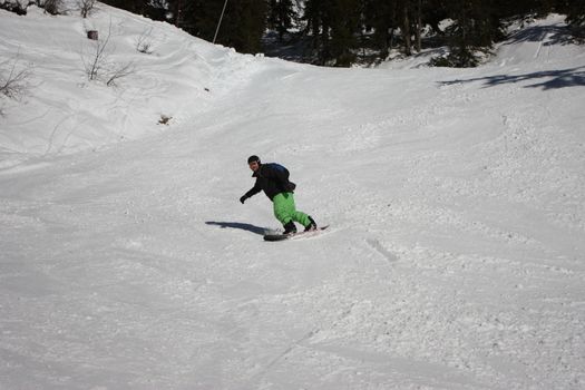 snowboarder carving a turn on an alpine piste