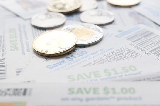 Coquitlam, BC, Canada - July 22, 2014 : Close up coupons and money, saving money concept. All coupons for Canadian store, they are issued by manufacturers of consumer packaged goods or by retailers in Canada. 