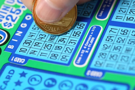 Coquitlam BC Canada - June 15, 2014 : Woman scratching lottery ticket called Bingo. It's published by BC Lottery Corporation has provided government sanctioned lottery games.