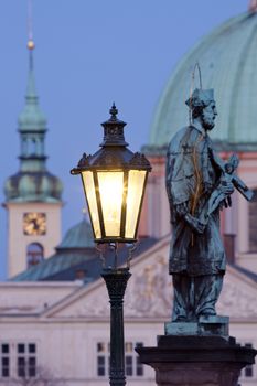 prague - religious art on charles bridge, lanterns and spires of the old town