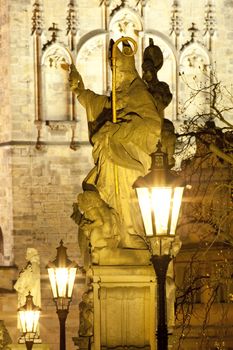 prague - religious art on charles bridge, lanterns and spire.