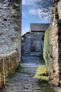 a tight alleyway in youlgreave between some old stone buildings