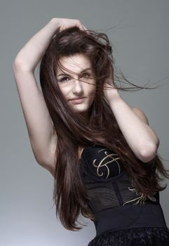 portrait of a young girl with long brown hair - isolated on gray