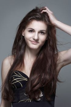 portrait of a young girl with long brown hair - isolated on gray