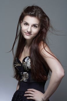 portrait of a young girl with long brown hair - isolated on gray