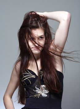 portrait of a young girl with long brown hair - isolated on gray