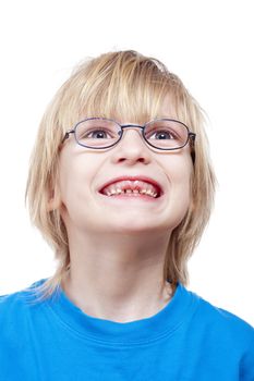 portrait of a boy with glasses showing his first missing milk teeth