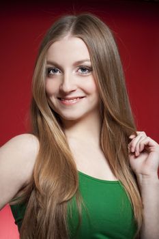 portrait of a young beautiful woman with brown hair against red background