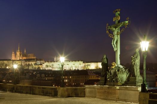 prague in winter - charles bridge and hradcany castle at dusk