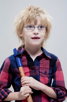 boy with missing milk teeth and glasses holding his flute - isolated on gray