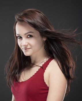 portrait of a teenage girl with brown hair against gray background
