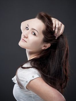 portrait of a teenage girl with brown hair against gray background