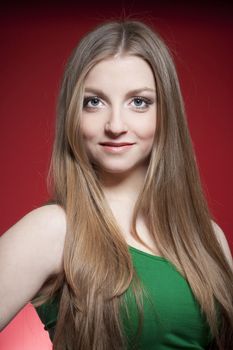 portrait of a young beautiful woman with brown hair against red background