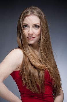 portrait of a young beautiful woman with brown hair against gray background