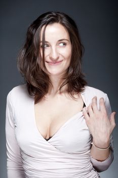 portrait of beautiful woman with brown hair looking - gray background