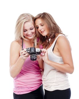 two young women viewing pictures in the camera - isolated on white