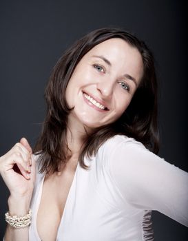 portrait of beautiful woman with brown hair smiling - gray background