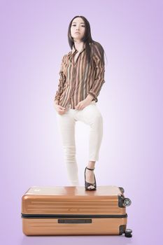 Modern Asian woman stand on a luggage.