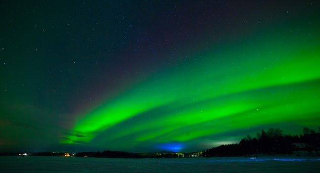 Intense northern lights - Aurora borealis over Lake in Finland